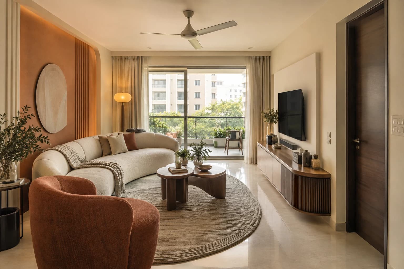 Cream curved sofa, rounded terracotta chair and pebble-shaped tables in an Indian flat